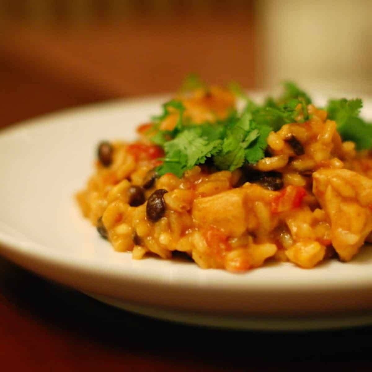 Cheesy black bean risotto on a white plate.
