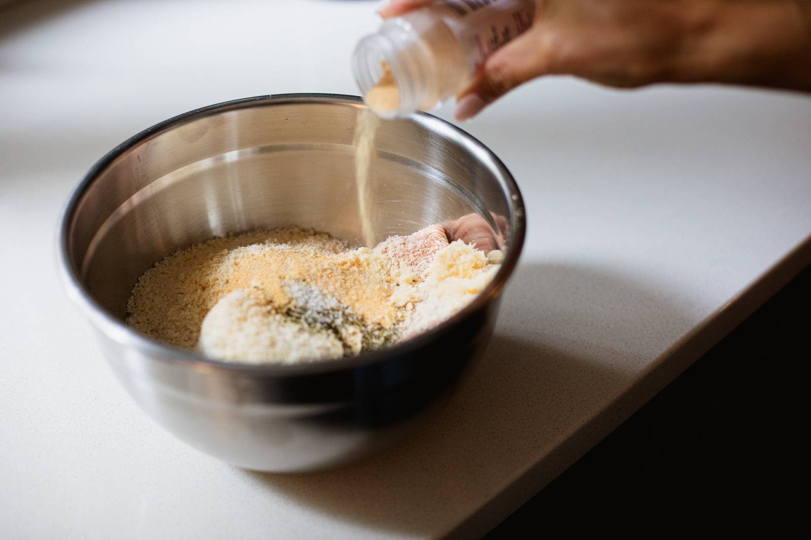 Mixing meatballs in a bowl.